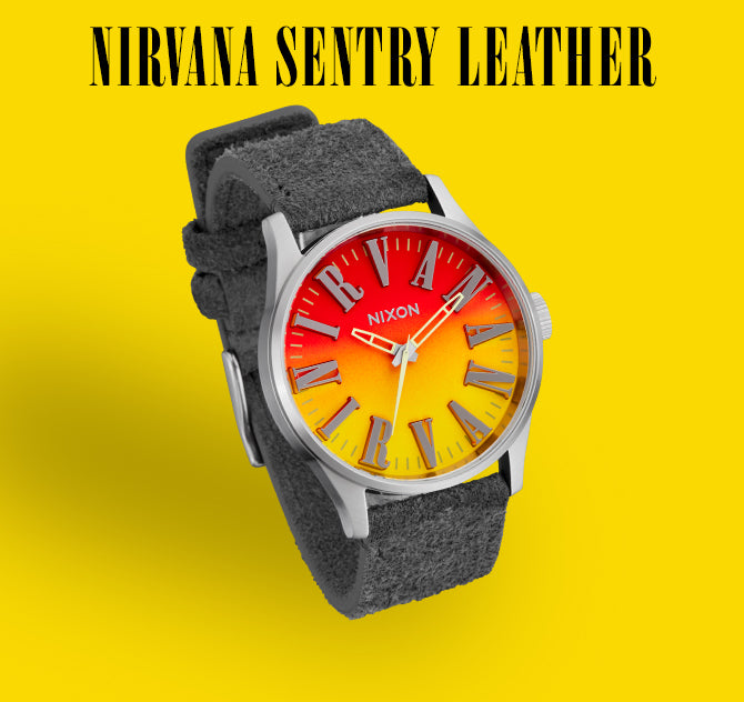 Nirvana Sentry Leather watch with a red to yellow gradient face and grey suede strap on a yellow background.