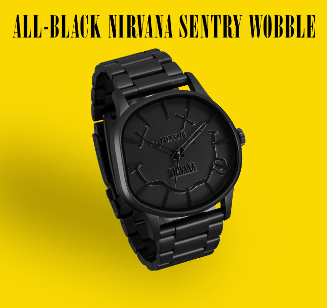 All-black Nixon Nirvana Sentry Wobble watch with smiley logo on yellow background.